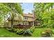A beautiful backyard with a wooden deck, screened in porch, landscaped garden, and a backdrop of lush green trees at 4541 Greenthread Ct, Zionsville, IN 46077