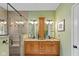Bright and modern bathroom with dual sinks, granite countertops, and a glass-enclosed shower at 4541 Greenthread Ct, Zionsville, IN 46077