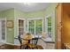Bright breakfast nook with wraparound windows, seat cushions, and a hardwood dining set at 4541 Greenthread Ct, Zionsville, IN 46077