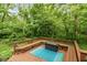 Wooden deck with built-in seating and fire pit, surrounded by lush greenery at 4541 Greenthread Ct, Zionsville, IN 46077