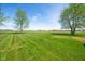Expansive backyard features lush lawn and mature trees, providing a serene outdoor space at 4622 W 400 S, Trafalgar, IN 46181