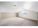 The bonus room showcases a slanted ceiling, neutral paint, and cozy carpeting at 4622 W 400 S, Trafalgar, IN 46181