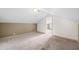 The bonus room showcases a slanted ceiling, neutral paint, and cozy carpeting at 4622 W 400 S, Trafalgar, IN 46181