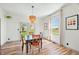 Bright dining room with wood floors, modern lighting, and scenic backyard views at 4622 W 400 S, Trafalgar, IN 46181