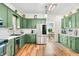 Bright kitchen features ample green cabinetry, stainless steel appliances, and hardwood floors at 4622 W 400 S, Trafalgar, IN 46181