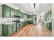 Updated kitchen featuring green cabinets, stainless steel appliances, and hardwood floors at 4622 W 400 S, Trafalgar, IN 46181