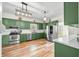 Bright kitchen with green cabinets, stainless appliances, and an overhead light fixture at 4622 W 400 S, Trafalgar, IN 46181
