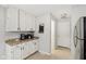 Well-lit kitchen featuring white cabinets, stainless steel refrigerator, and modern appliances at 4708 Dorkin Ct, Indianapolis, IN 46254