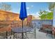 Cozy outdoor patio features a blue umbrella, metal table and chairs, surrounded by a brick privacy wall at 4708 Dorkin Ct, Indianapolis, IN 46254