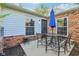 Inviting outdoor patio with a blue umbrella, metal table, and a brick-accented home exterior at 4708 Dorkin Ct, Indianapolis, IN 46254
