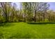 Lush green backyard featuring mature trees, offering a private and serene setting at 4731 Moss Creek Ct, Indianapolis, IN 46237