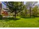 Expansive backyard features lush lawn, mature trees, and a glimpse of the inviting pool area, perfect for outdoor enjoyment at 4731 Moss Creek Ct, Indianapolis, IN 46237