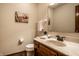 Well-lit half bathroom with wood vanity, ample countertop space, and essential fixtures at 4731 Moss Creek Ct, Indianapolis, IN 46237