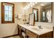 Bright bathroom featuring double sinks, a large mirror, and a window for natural light at 4731 Moss Creek Ct, Indianapolis, IN 46237