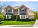 Charming two-story brick home with manicured lawn and lush greenery on a sunny day at 4731 Moss Creek Ct, Indianapolis, IN 46237