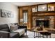 Inviting living room featuring a brick fireplace, wood paneling, and comfortable seating at 4731 Moss Creek Ct, Indianapolis, IN 46237