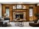 Charming living room featuring brick fireplace, wood paneling, and comfortable seating arrangement at 4731 Moss Creek Ct, Indianapolis, IN 46237