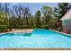 Sparkling blue pool with a large patio area and green surroundings at 4731 Moss Creek Ct, Indianapolis, IN 46237