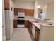 Functional kitchen featuring wood cabinets, white appliances, and tile flooring, perfect for cooking and dining at 5341 Spring Creek Ct, Indianapolis, IN 46254