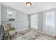 Bright bedroom with neutral walls, carpeted floor, and a seating area by the window at 540 S Broadway St, Atlanta, IN 46031