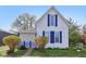 A quaint home featuring blue shutters, a covered porch, and mature landscaping at 540 S Broadway St, Atlanta, IN 46031