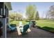 Outdoor patio features chairs, a grill, and a spacious lawn lined with mature trees at 5624 Ottawa Pass, Carmel, IN 46033