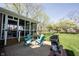 Outdoor patio features chairs, a grill, and a spacious lawn leading up to the enclosed porch at 5624 Ottawa Pass, Carmel, IN 46033