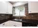 Bright kitchen features a stainless steel sink and faucet overlooking a window at 5624 Ottawa Pass, Carmel, IN 46033