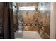 Tiled tub/shower with window featuring stone-look tiling with decorative accent diamonds at 5624 Ottawa Pass, Carmel, IN 46033