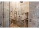 Detailed shower with stone-look tile, mounted shower head, and tiled shelving at 5624 Ottawa Pass, Carmel, IN 46033