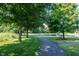 A concrete walking path winds through a neighborhood park and ends at a bench facing a pond at 5624 Ottawa Pass, Carmel, IN 46033