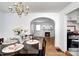 Cozy dining room featuring hardwood floors, a chandelier, and a view into the living room and kitchen at 5933 Guilford Ave, Indianapolis, IN 46220