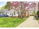 A cozy brick home with a lush green lawn and a beautiful tree with pink blooms at 5933 Guilford Ave, Indianapolis, IN 46220