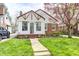 Charming home featuring a manicured lawn and a lovely tree with vibrant red blossoms at 5933 Guilford Ave, Indianapolis, IN 46220