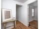 A light filled hallway decorated with a framed print resting on a wooden table and hardwood floors at 5933 Guilford Ave, Indianapolis, IN 46220