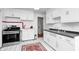 Bright kitchen featuring white cabinets, a stainless steel gas range and oven and a decorative area rug at 5933 Guilford Ave, Indianapolis, IN 46220