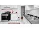 Bright kitchen featuring white cabinets, a stainless steel gas range and oven and a decorative area rug at 5933 Guilford Ave, Indianapolis, IN 46220
