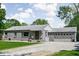 Attractive single-story home with gray brick, a two-car garage, a gravel driveway, and front yard at 6223 N Parker Ave, Indianapolis, IN 46220
