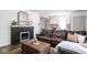 Cozy living room with a dark fireplace, a leather sofa, and a plush ottoman on hardwood floors at 6223 N Parker Ave, Indianapolis, IN 46220