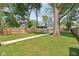 Fenced backyard with a well-maintained lawn, mature trees and a concrete drive at 625 N Temple Ave, Indianapolis, IN 46201