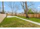 Spacious backyard featuring a fenced perimeter, a paved patio area, and mature trees at 625 N Temple Ave, Indianapolis, IN 46201
