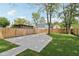 Backyard features a large concrete driveway, mature trees, a wooden fence and a grassy area at 625 N Temple Ave, Indianapolis, IN 46201