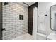 Modern bathroom features a tiled shower with black hardware, contrasting with the white and gray color scheme at 625 N Temple Ave, Indianapolis, IN 46201