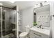 Bathroom with gray vanity, modern fixtures, shelving and walk-in shower featuring marble-look tiles at 625 N Temple Ave, Indianapolis, IN 46201