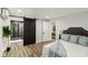 Modern bedroom with a sliding barn door leading to the bathroom and an open doorway to another room at 625 N Temple Ave, Indianapolis, IN 46201