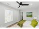 Bright bedroom with hardwood floors, ceiling fan, large window, neutral paint, and ensuite bathroom at 625 N Temple Ave, Indianapolis, IN 46201
