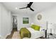 Cozy bedroom featuring hardwood floors, ensuite bathroom, modern fan and decor, with bright, neutral paint at 625 N Temple Ave, Indianapolis, IN 46201