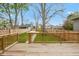 Large wooden deck overlooking a fenced yard and a paved walkway in the backyard at 625 N Temple Ave, Indianapolis, IN 46201