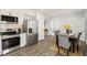 Eat-in kitchen with white cabinets, stainless steel appliances, and an open dining area with seating for six at 625 N Temple Ave, Indianapolis, IN 46201
