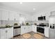 Modern kitchen with stainless steel appliances, white cabinetry, and granite countertops at 625 N Temple Ave, Indianapolis, IN 46201